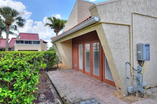 view of exterior entry featuring a patio and stucco siding