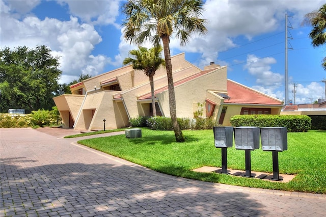 exterior space featuring a yard and mail area