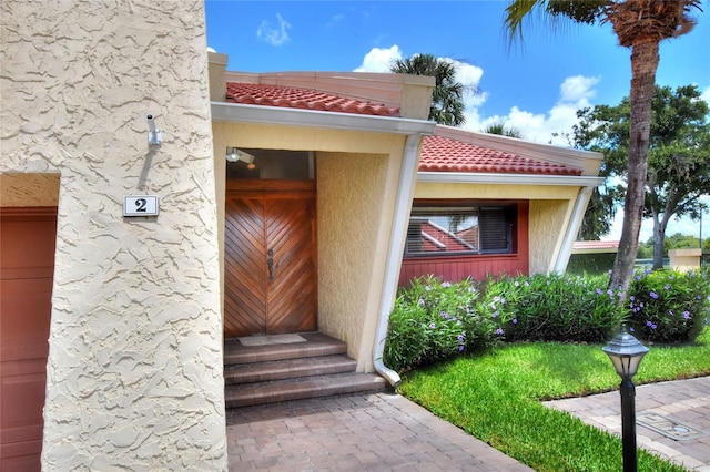 property entrance with a tiled roof and stucco siding