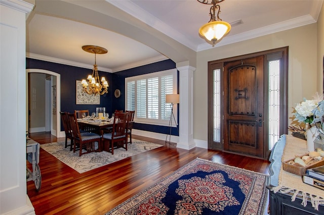 entryway featuring dark hardwood / wood-style floors, crown molding, and a chandelier