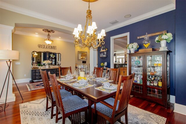 dining room featuring crown molding, dark hardwood / wood-style flooring, a chandelier, and sink