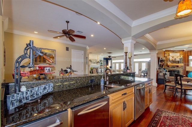 kitchen with dishwasher, dark stone counters, crown molding, ceiling fan, and dark hardwood / wood-style flooring