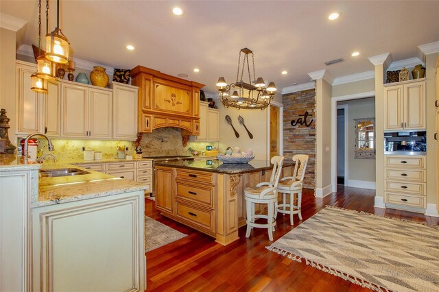 kitchen featuring sink, a center island, hanging light fixtures, and dark hardwood / wood-style floors