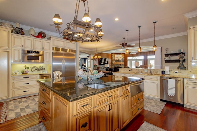 kitchen featuring sink, hanging light fixtures, stainless steel appliances, dark hardwood / wood-style flooring, and ceiling fan with notable chandelier