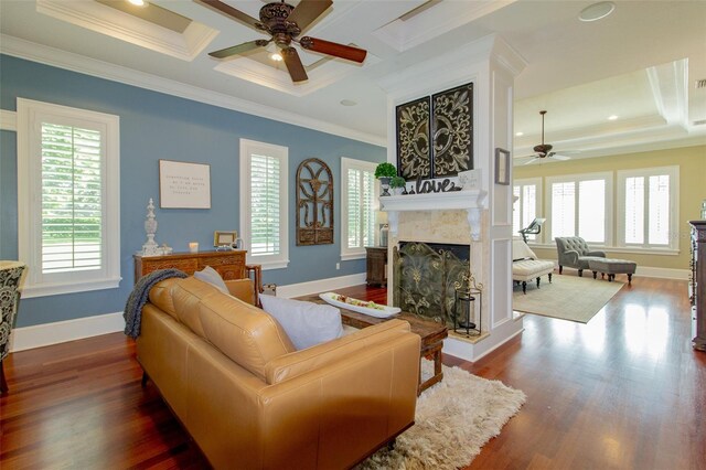 living room featuring coffered ceiling, ceiling fan, crown molding, wood-type flooring, and a premium fireplace