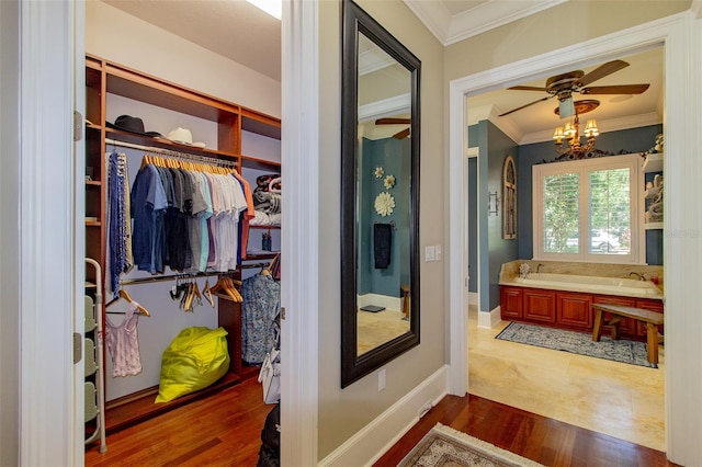 bathroom featuring wood-type flooring, a bathtub, ornamental molding, and a notable chandelier