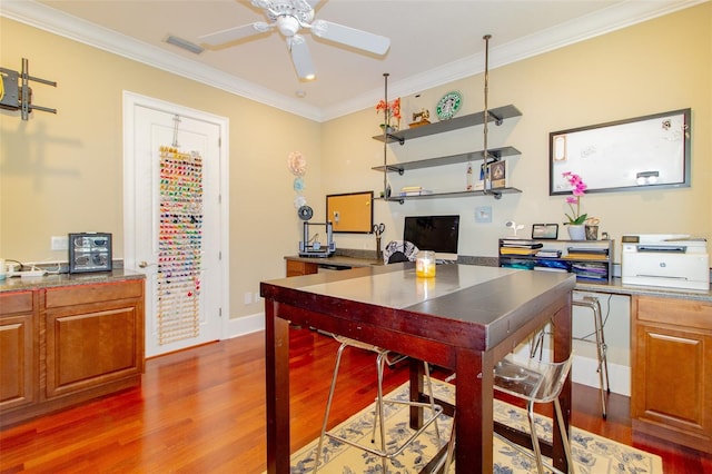 home office with crown molding, ceiling fan, and dark wood-type flooring