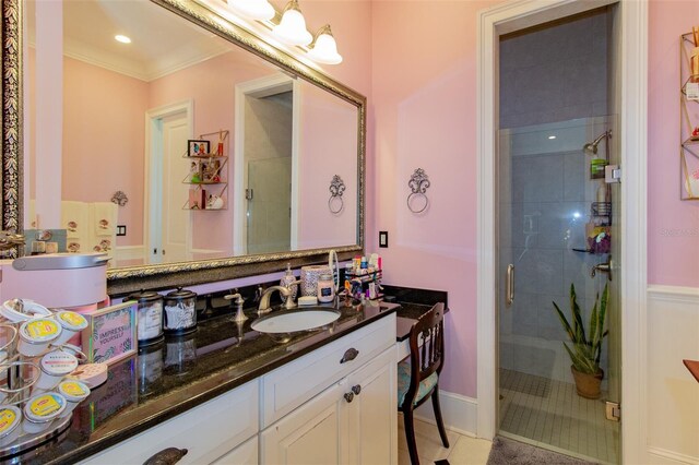 bathroom with tile patterned floors, crown molding, vanity, and a shower with shower door