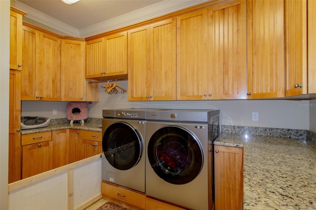 laundry room with separate washer and dryer, crown molding, and cabinets