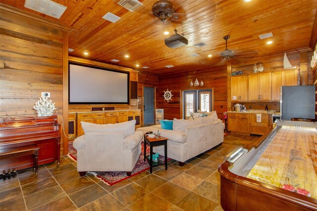 home theater featuring french doors, wooden walls, ceiling fan, and wooden ceiling