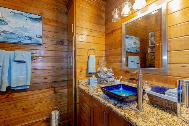 bathroom with vanity and wooden walls