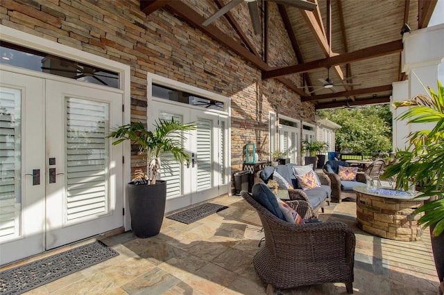 view of patio featuring ceiling fan, an outdoor living space with a fire pit, and french doors