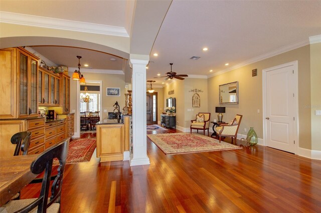 interior space with ceiling fan with notable chandelier, hanging light fixtures, dark hardwood / wood-style floors, and ornamental molding