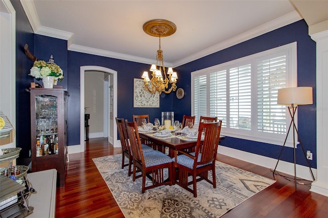 dining area featuring crown molding, dark wood-type flooring, and a notable chandelier