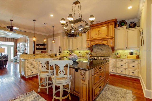 kitchen featuring dark hardwood / wood-style flooring, kitchen peninsula, crown molding, pendant lighting, and a breakfast bar area