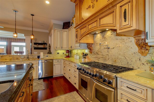 kitchen with appliances with stainless steel finishes, tasteful backsplash, pendant lighting, and dark stone countertops