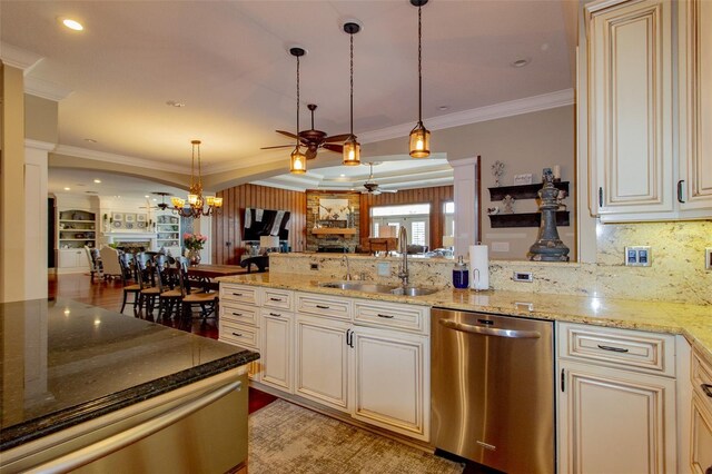 kitchen with sink, stainless steel dishwasher, light hardwood / wood-style floors, ceiling fan with notable chandelier, and ornamental molding