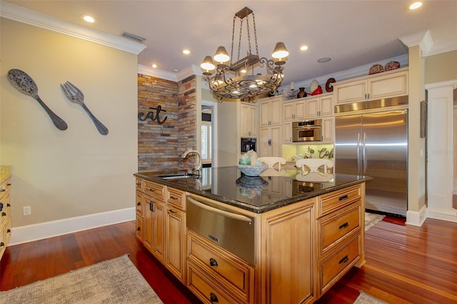 kitchen with stainless steel appliances, a kitchen island with sink, dark wood-type flooring, sink, and hanging light fixtures