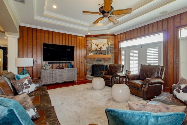 living room with wooden walls, plenty of natural light, and ornamental molding