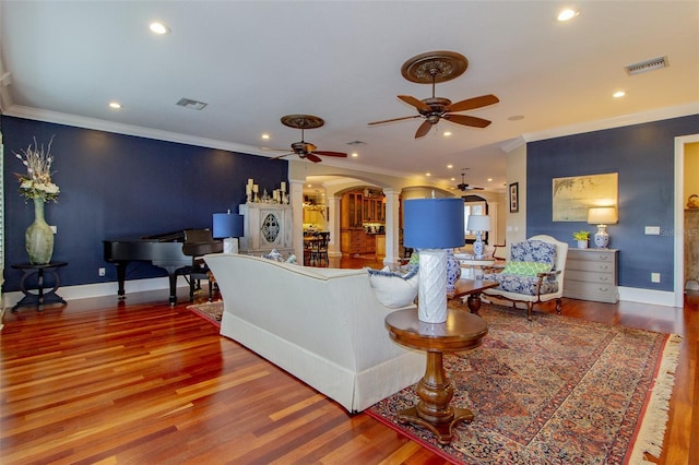 living room with crown molding, ceiling fan, and hardwood / wood-style flooring