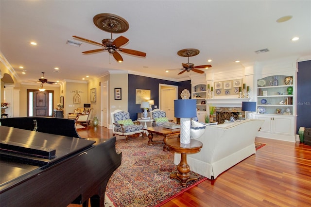 living room with ceiling fan, ornamental molding, and hardwood / wood-style flooring