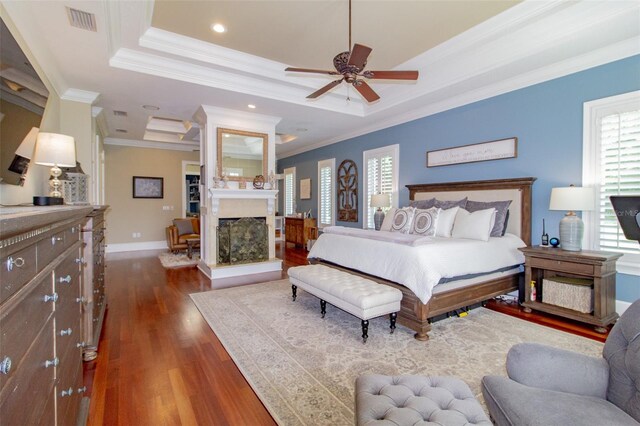 bedroom featuring dark hardwood / wood-style flooring, a raised ceiling, ceiling fan, and crown molding