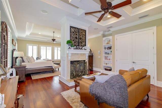 bedroom featuring ceiling fan, dark hardwood / wood-style flooring, a high end fireplace, crown molding, and a closet