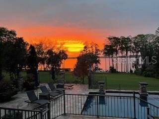 pool at dusk with a patio area