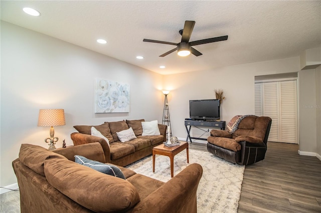 living room with wood-type flooring, ceiling fan, and a textured ceiling