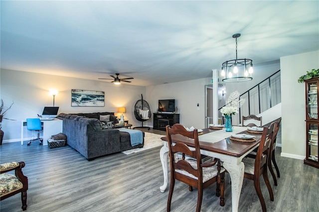 dining space featuring ceiling fan with notable chandelier and wood-type flooring