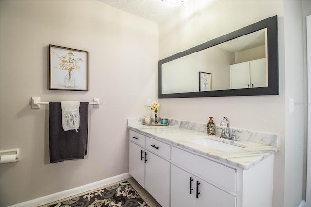 bathroom with vanity, tile patterned flooring, and a textured ceiling