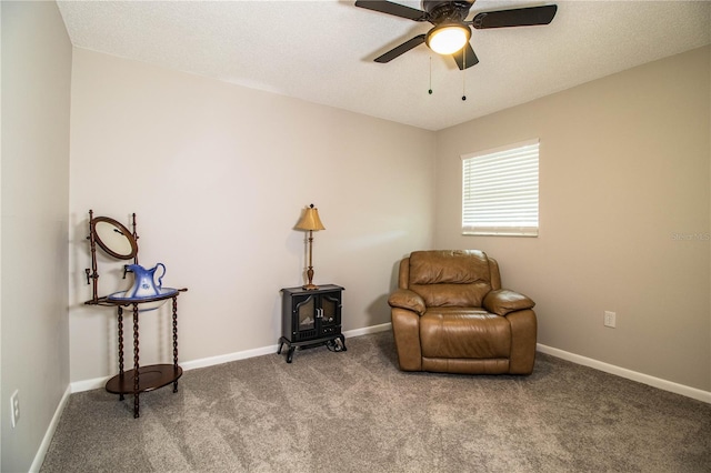 sitting room featuring ceiling fan, carpet floors, and a textured ceiling