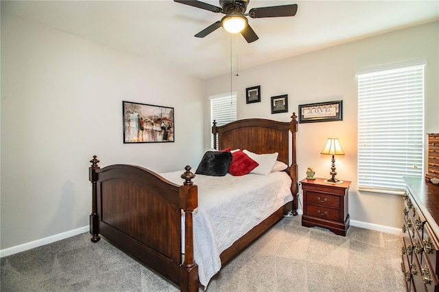 bedroom featuring light carpet, multiple windows, and ceiling fan