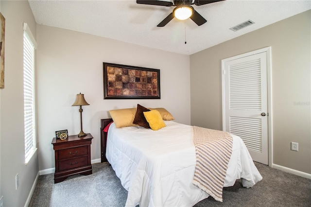 bedroom with multiple windows, carpet, ceiling fan, and a closet