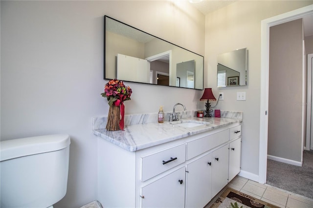 bathroom featuring vanity, tile patterned floors, and toilet