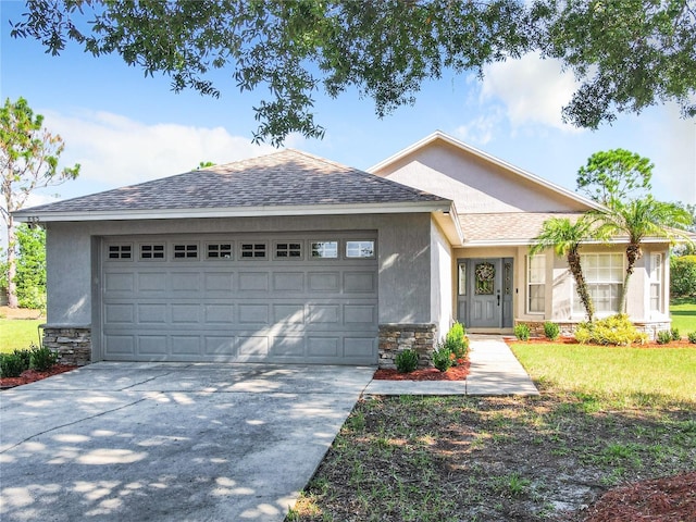 ranch-style house with a shingled roof, stone siding, concrete driveway, and stucco siding