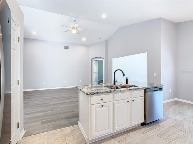 kitchen featuring white cabinets, a ceiling fan, a kitchen island with sink, stainless steel dishwasher, and a sink