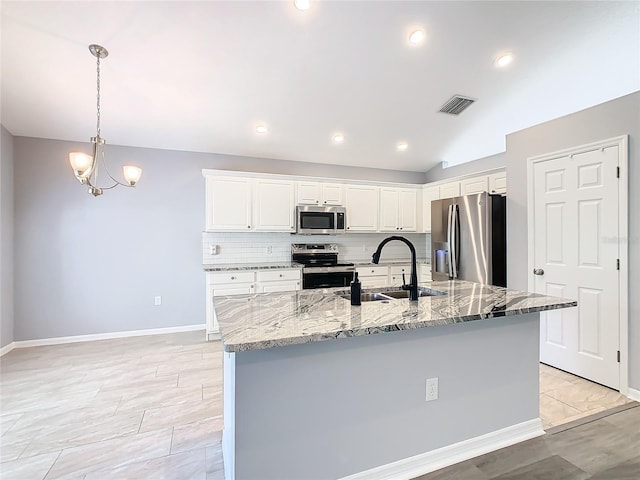 kitchen with stainless steel appliances, a large island with sink, white cabinets, and a sink