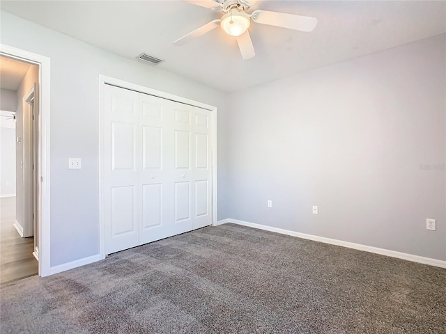 unfurnished bedroom featuring baseboards, visible vents, ceiling fan, carpet flooring, and a closet