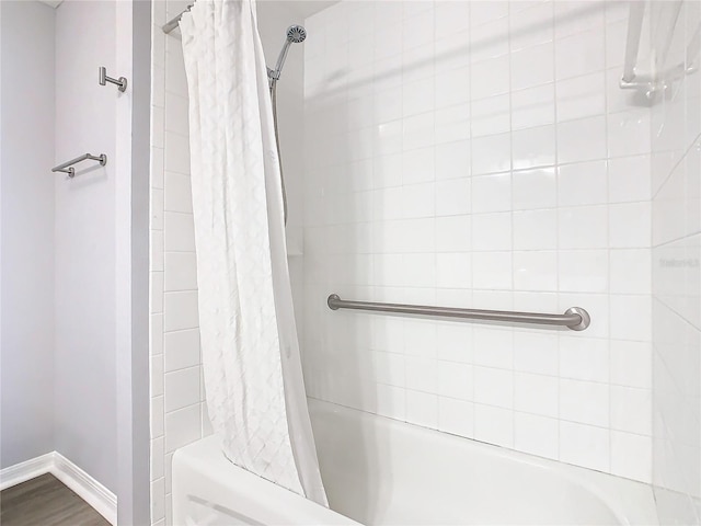 full bath with baseboards and shower / bath combo with shower curtain