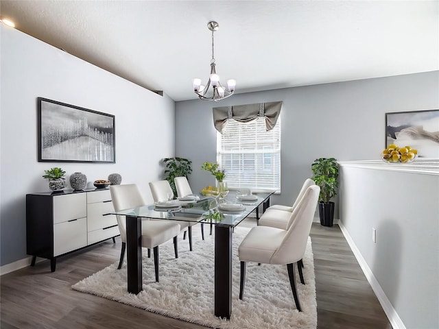 dining space featuring a notable chandelier, baseboards, and wood finished floors