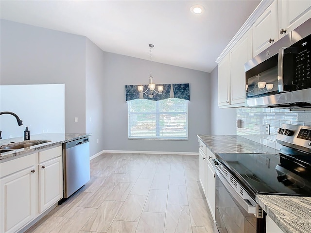 kitchen featuring white cabinets, vaulted ceiling, a chandelier, a sink, and stainless steel appliances
