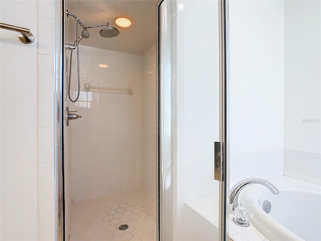 bathroom featuring a shower stall and a bath