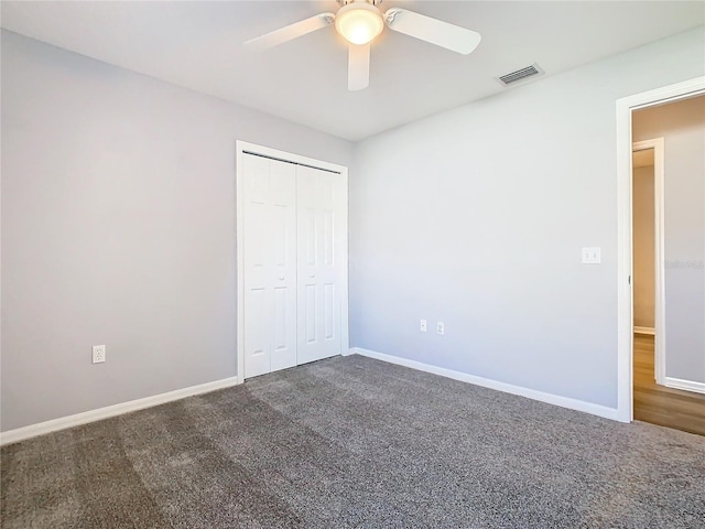 unfurnished bedroom featuring carpet floors, baseboards, a closet, and visible vents