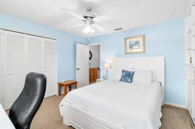 bedroom with a closet, light carpet, ceiling fan, and visible vents