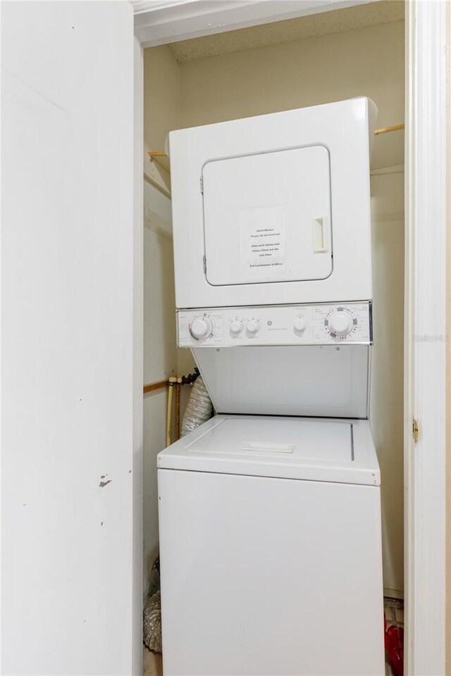 clothes washing area with laundry area and stacked washer / drying machine