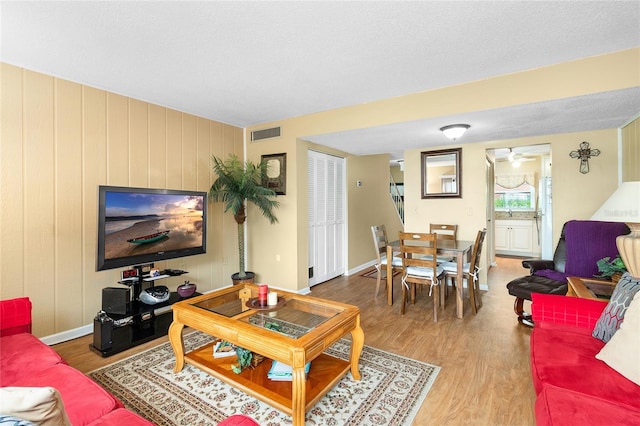 living area featuring wood finished floors, visible vents, and baseboards