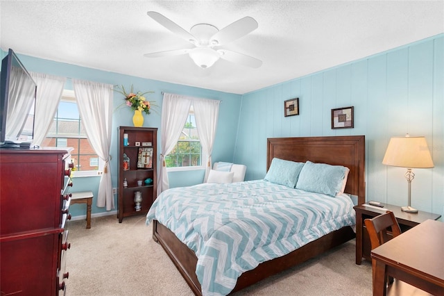 carpeted bedroom with a ceiling fan and a textured ceiling