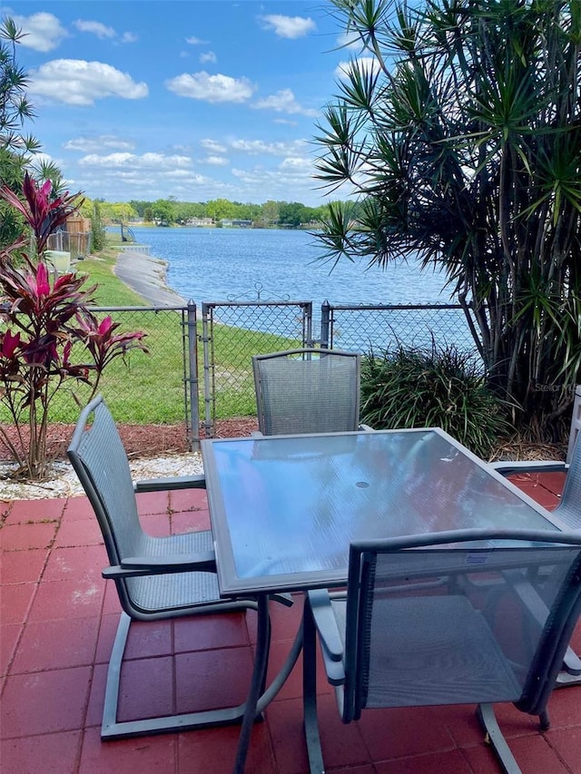 1920 E Edgewood Dr Unit G5, Lakeland, FL 33803 - view of patio featuring a water view and outdoor dining area