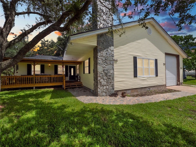 exterior space featuring a garage and a lawn